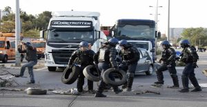 French gendarmes remove tyres and branches after striking workers blockaded roads near the oil terminal at Fos-sur-Mer