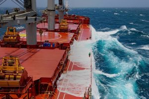 stock-photo-cargo-ship-rolling-in-stormy-sea-huge-waves-under-blue-sky-in-indian-ocean-1167157969
