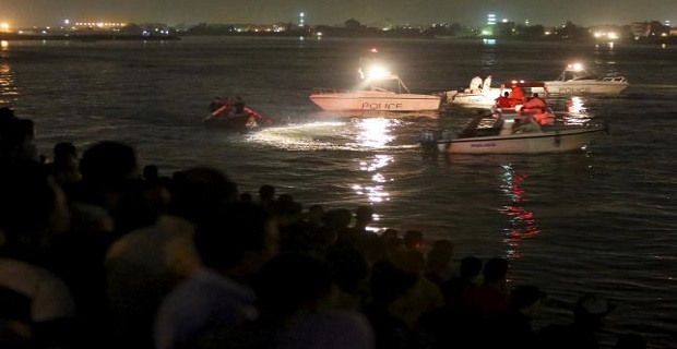 People gather along the banks of the Nile River during a search for the victims of a boat accident on the River Nile in the Warraq area of Giza